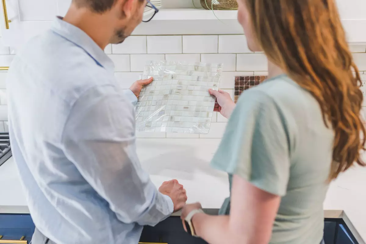 Zwei Personen vergleichen Materialmuster für die Gestaltung einer Küche